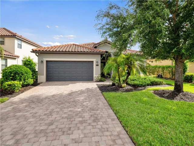 Mediterranean / spanish-style house with a garage and a front lawn