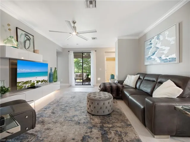 Living room featuring ornamental molding and ceiling fan