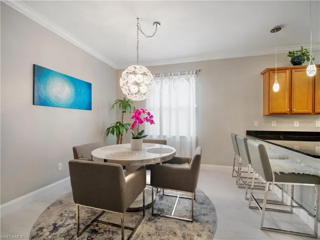Dining room with light hardwood / wood-style floors and crown molding