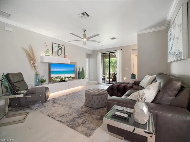 Living room featuring ceiling fan, wood-type flooring, and ornamental molding