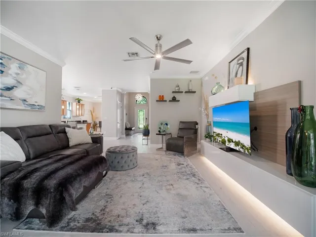 Living room featuring ornamental molding, a wealth of natural light, and ceiling fan