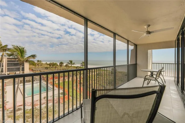 Balcony featuring ceiling fan and a water view