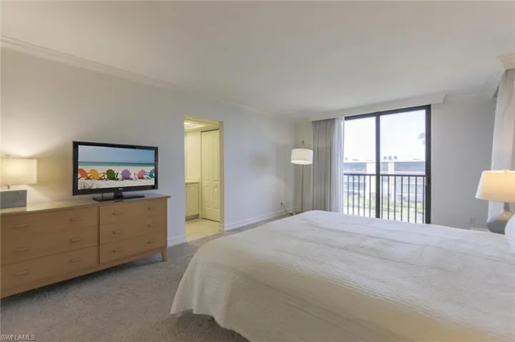 Carpeted bedroom featuring access to exterior and ornamental molding