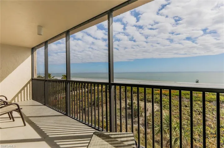 Balcony featuring a view of the beach and a water view