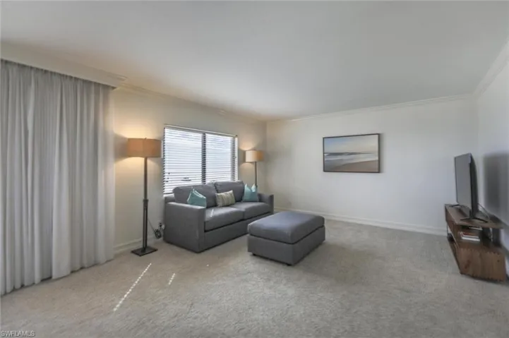 Carpeted living room featuring ornamental molding