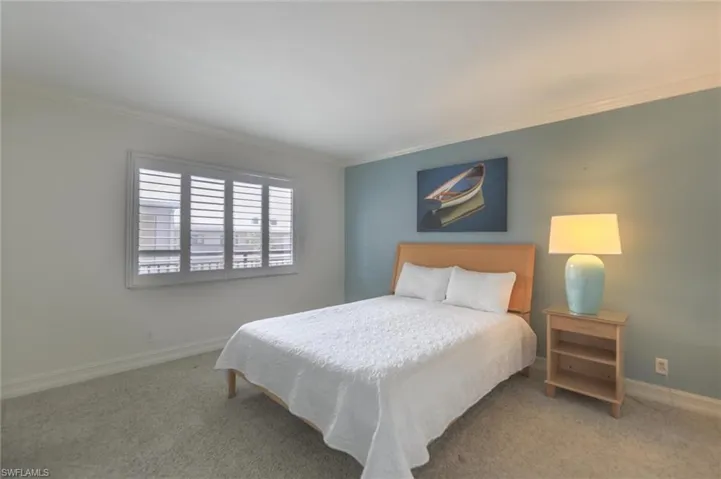 Carpeted bedroom featuring crown molding