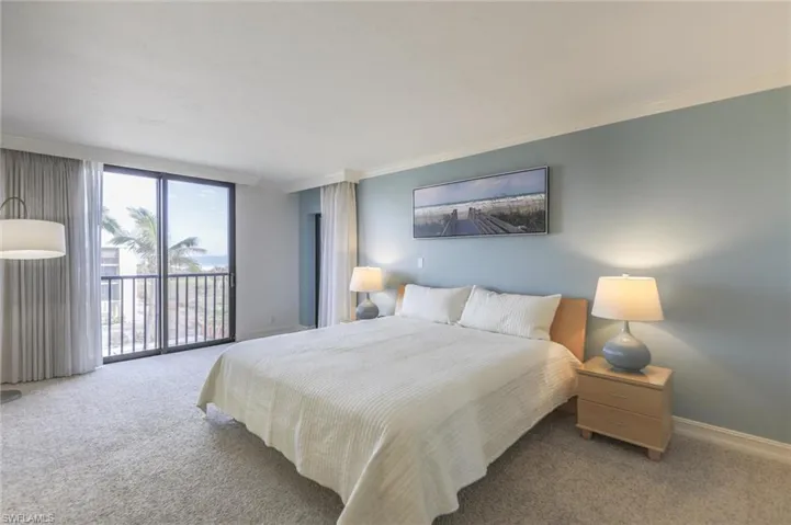 Bedroom featuring light colored carpet, crown molding, and access to outside