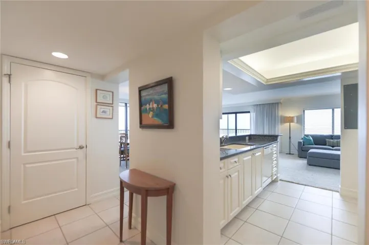 Corridor featuring light tile patterned floors and sink