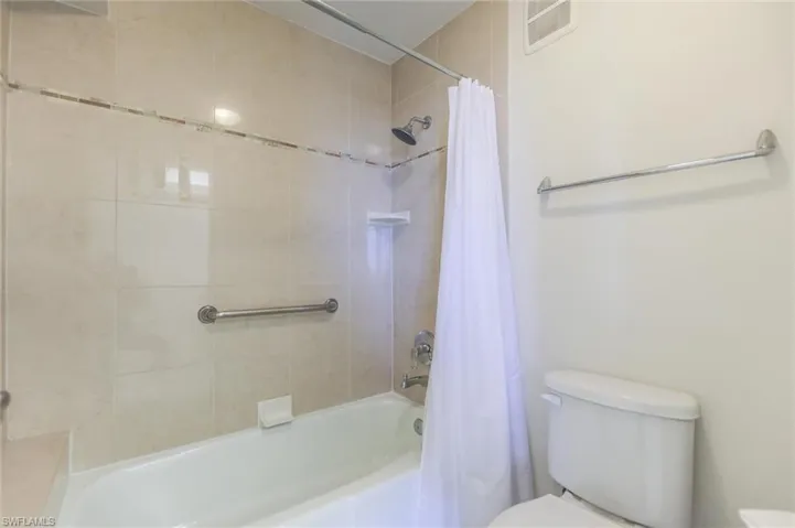 Bathroom featuring shower / tub combo and toilet