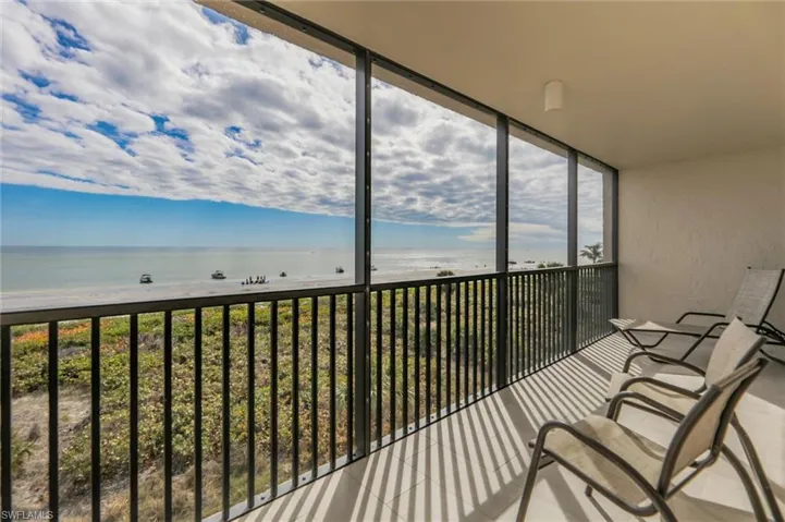 Unfurnished sunroom with a water view and a beach view