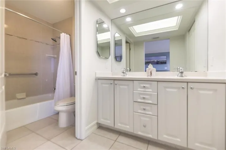 Full bathroom featuring toilet, shower / bath combo, vanity, and tile patterned floors