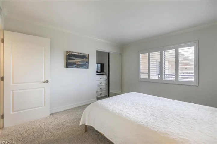 Carpeted bedroom with ornamental molding