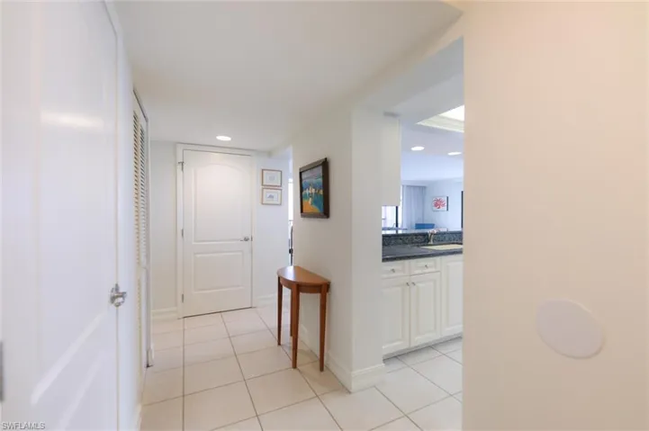 Corridor featuring light tile patterned floors and sink