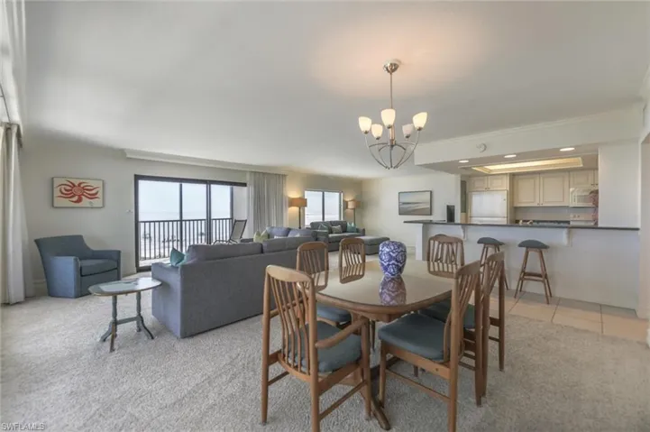 Tiled dining space featuring an inviting chandelier and crown molding
