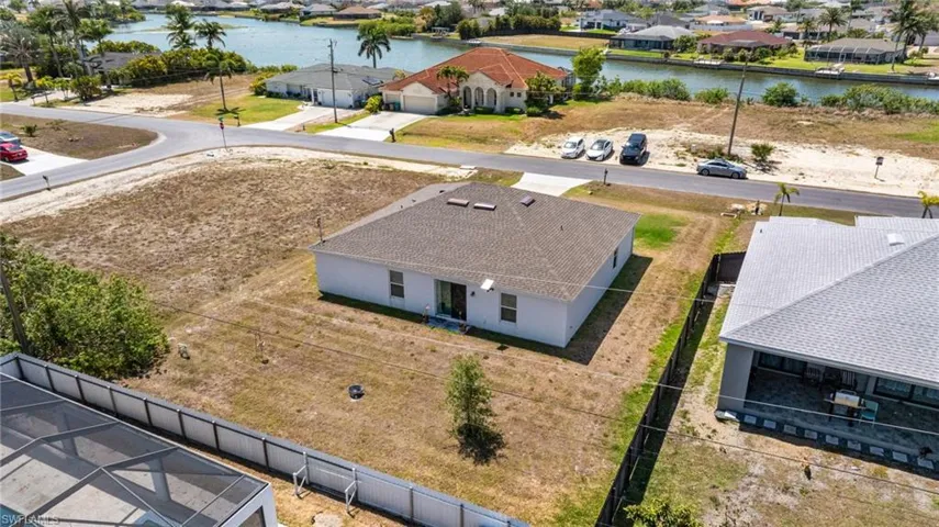 Birds eye view of property with a water view and a residential view