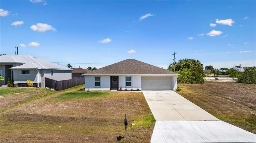 Single story home featuring a garage, fence, a front yard, and concrete driveway