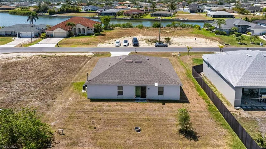 Birds eye view of property with a water view and a residential view