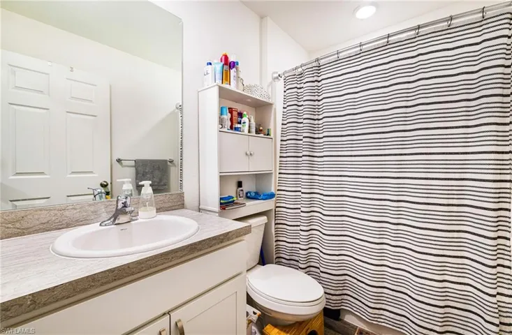 Guest Bathroom with toilet, vanity, and a shower with shower curtain