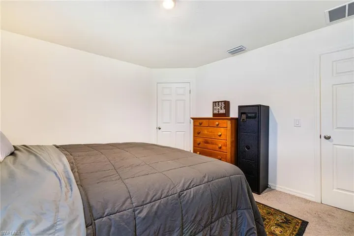 Primary Carpeted bedroom with baseboards and visible vents