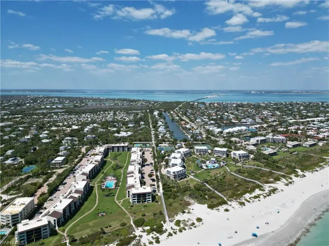 Aerial perspective showcasing beachfront properties alongside a waterway and extensive coastal development