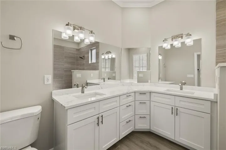 Dual vanity with white cabinetry, integrated sinks, white countertops, and brushed nickel hardware