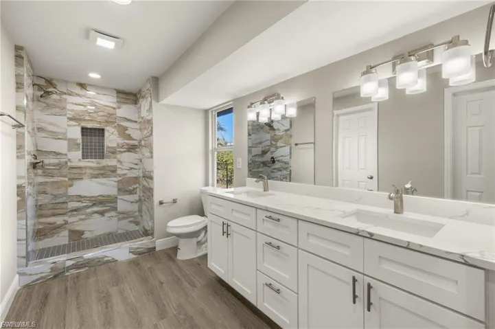 Double vanity with white cabinetry and integrated sinks set in a stone-look countertop