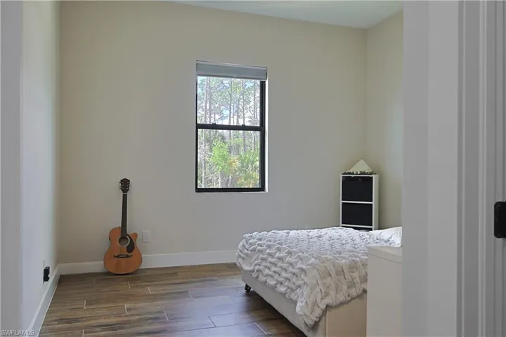 Bedroom with wood tiled floors and baseboards