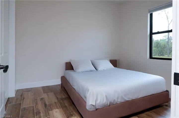 Bedroom with wood tiled floors and baseboards