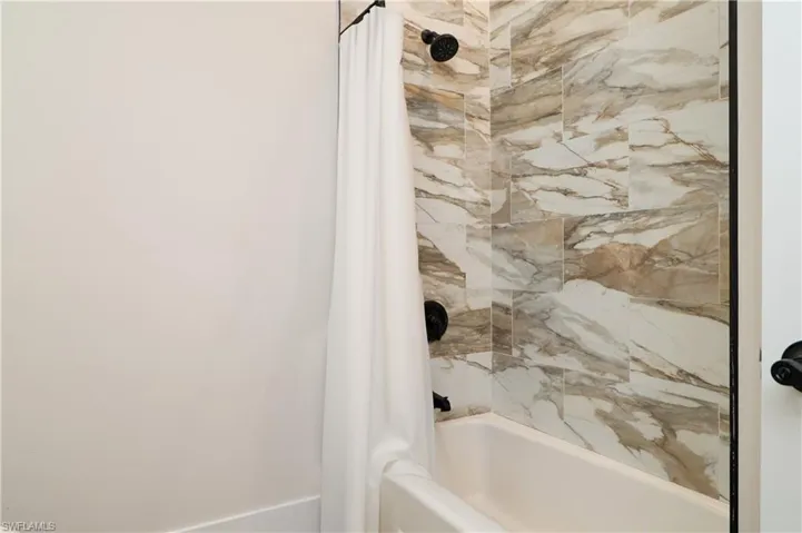 Bathroom featuring shower / bathtub combination with curtain