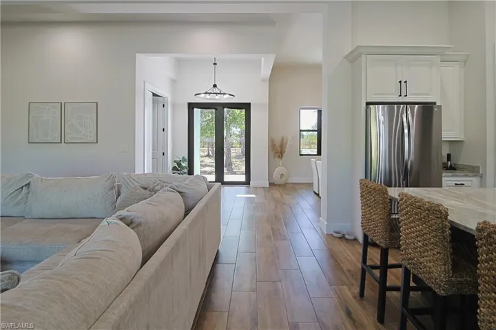 Living room with dark wood finished floors and suspended lighting