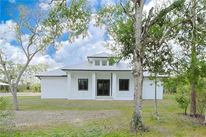 Back of property featuring a yard, stucco siding, and a porch