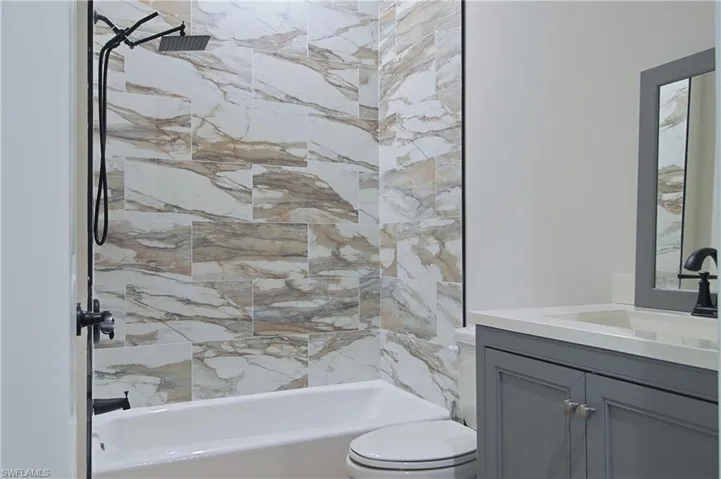 Bathroom with vanity and washtub / shower combination