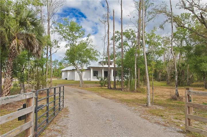 View of front of house with a gate, driveway, and a garage
