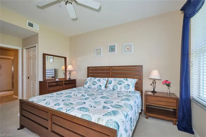 Carpeted bedroom with baseboards, visible vents, and a ceiling fan