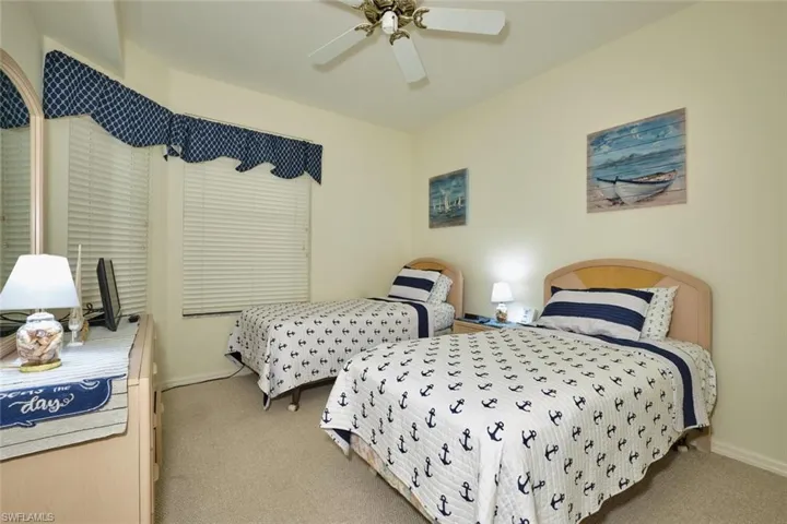 Carpeted bedroom featuring baseboards and a ceiling fan