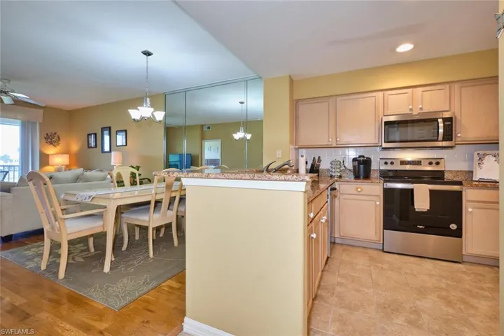 Kitchen with pendant lighting, tasteful backsplash, appliances with stainless steel finishes, a peninsula, and open floor plan