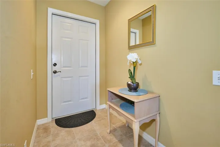Doorway to outside with baseboards and light tile patterned flooring