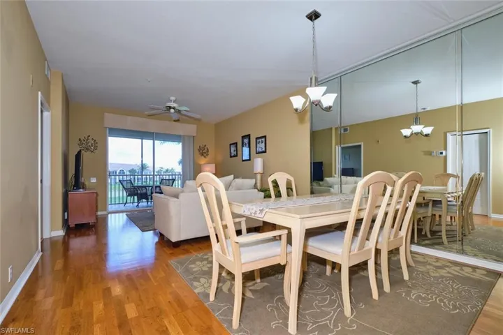 Dining area featuring baseboards, wood finished floors, and ceiling fan with notable chandelier