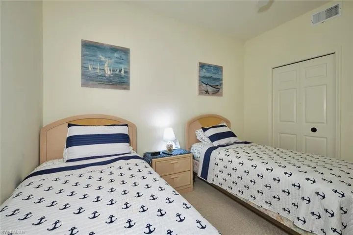 Bedroom with visible vents, carpet, and a ceiling fan