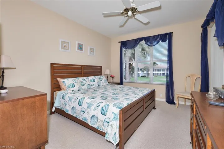 Carpeted bedroom with baseboards and ceiling fan