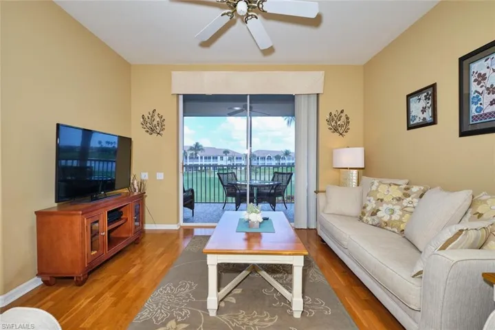 Living room featuring wood finished floors, baseboards, and ceiling fan