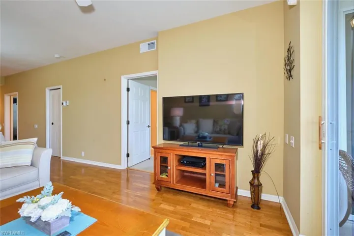 Living area with wood finished floors, baseboards, and visible vents