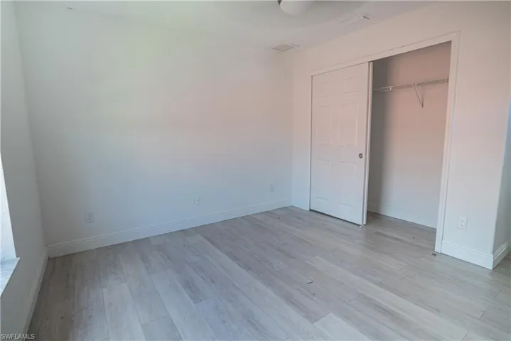 Unfurnished bedroom featuring light wood-style floors, a ceiling fan, and a closet