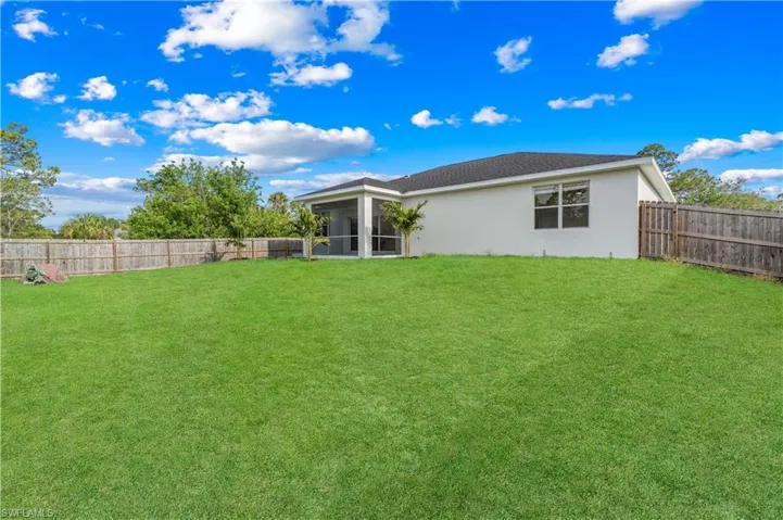 View of yard featuring a fenced backyard and a sunroom
