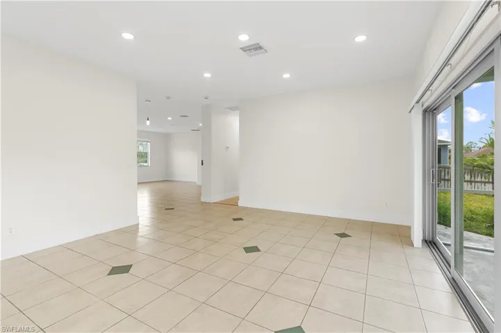 Empty room featuring light tile patterned floors, baseboards, recessed lighting, and visible vents