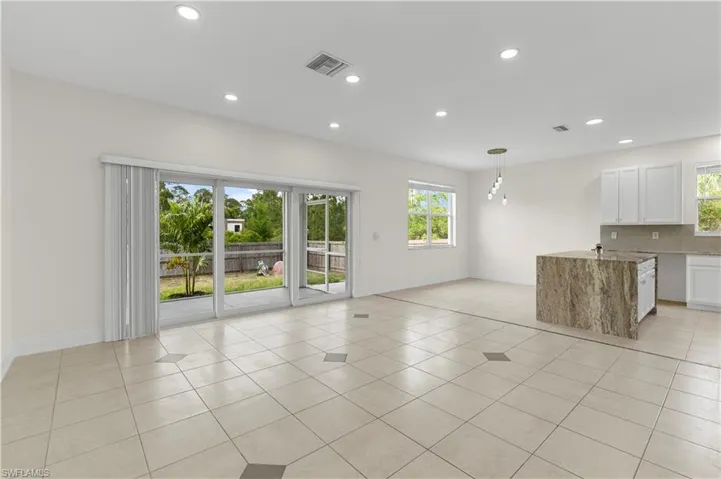 Unfurnished living room with recessed lighting, baseboards, and a wealth of natural light