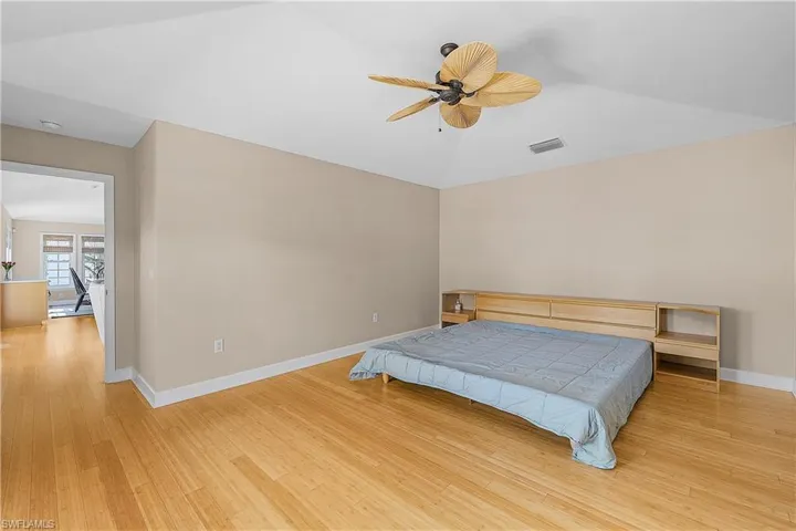 Bedroom with vaulted ceiling, ceiling fan, and wood-style floors