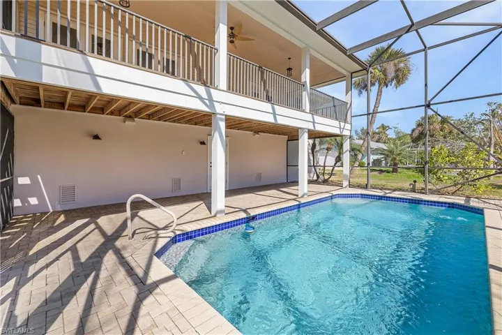 View of pool featuring ceiling fan, a patio area, and screened enclosure