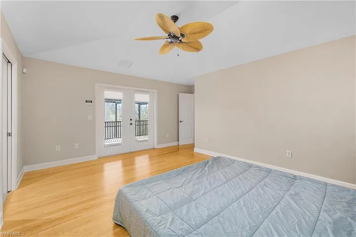 Bedroom featuring french doors, ceiling fan, and wood-style floors