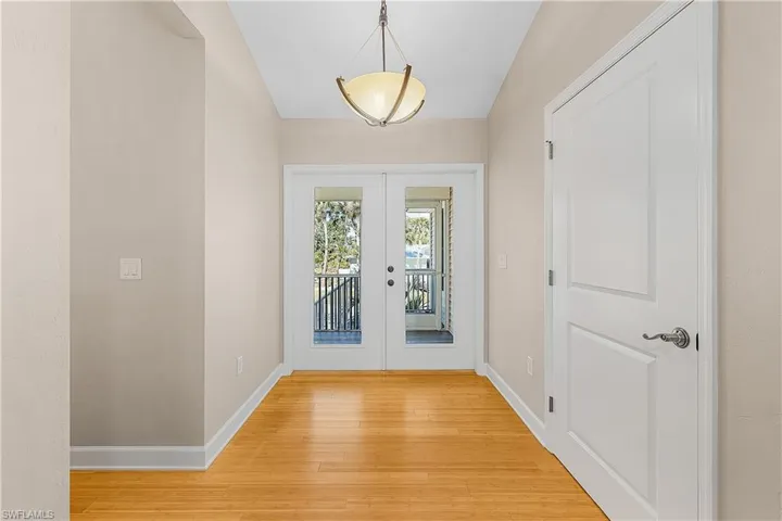 Entryway featuring wood-style flooring, chandelier, and french doors